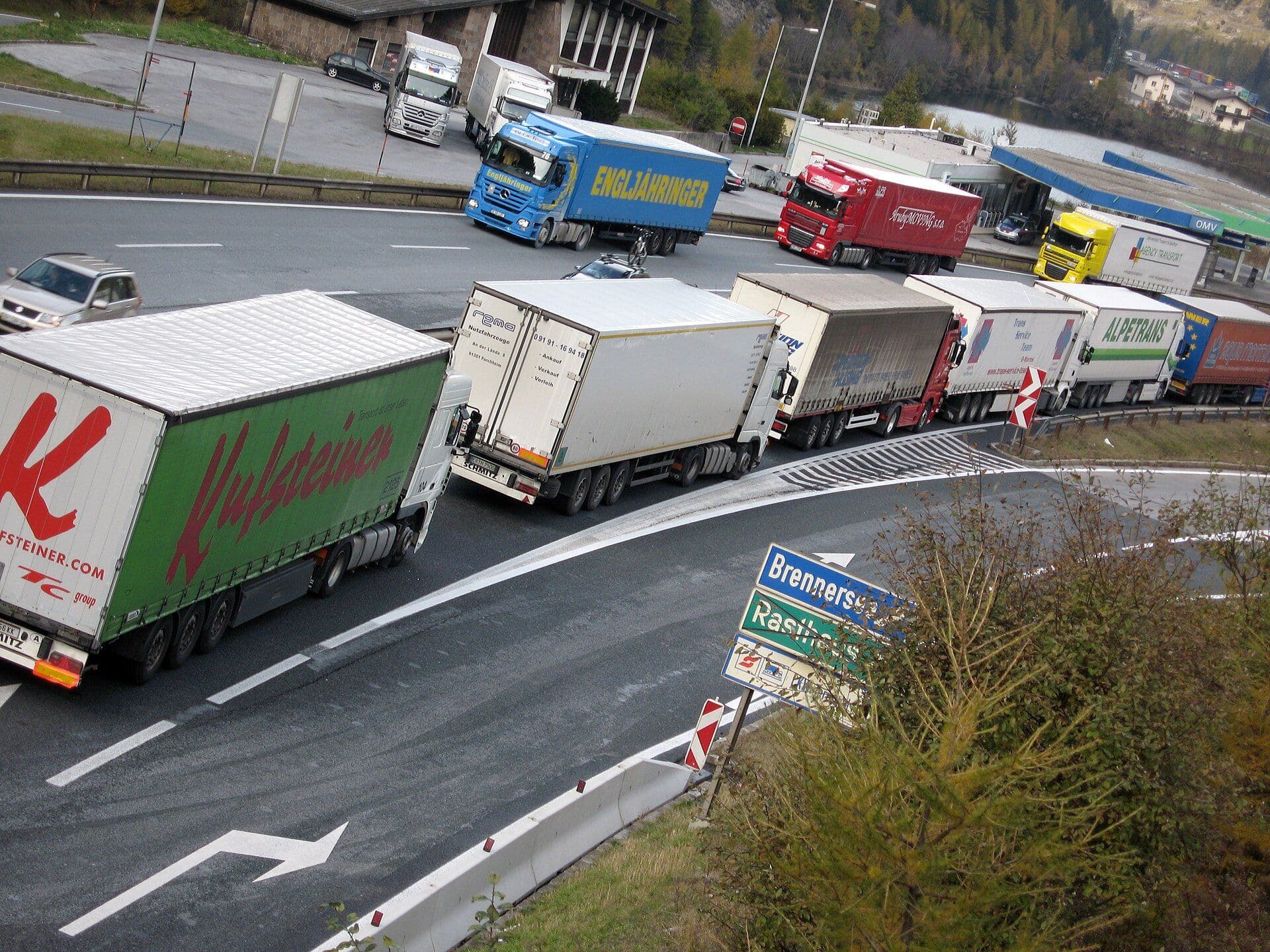 Line of freight trucks moving along a motorway corridor
