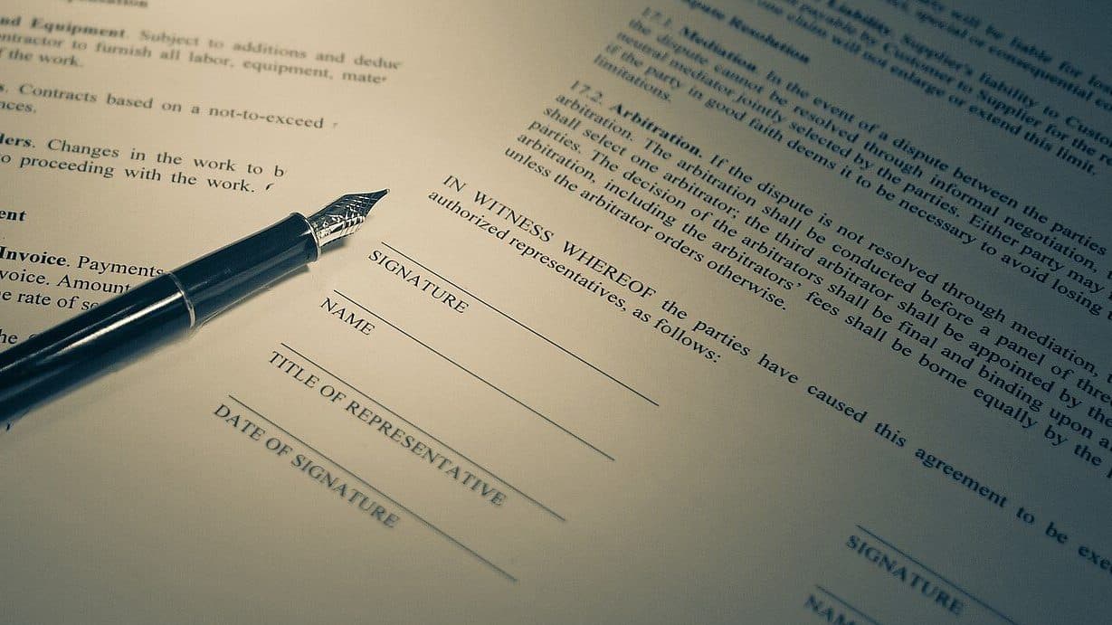 Fountain pen resting on an agreement's signature lines